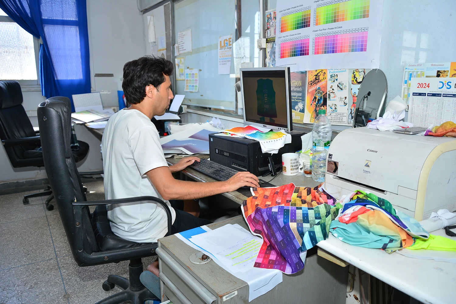 Graphiste d'ANAELI qui conçoit une tenue sportive personnalisée sur un ordinateur